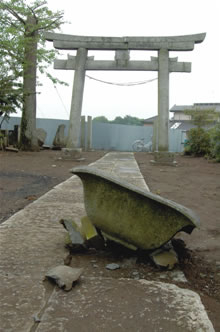 震災のために倒壊した神社の燈篭の写真
